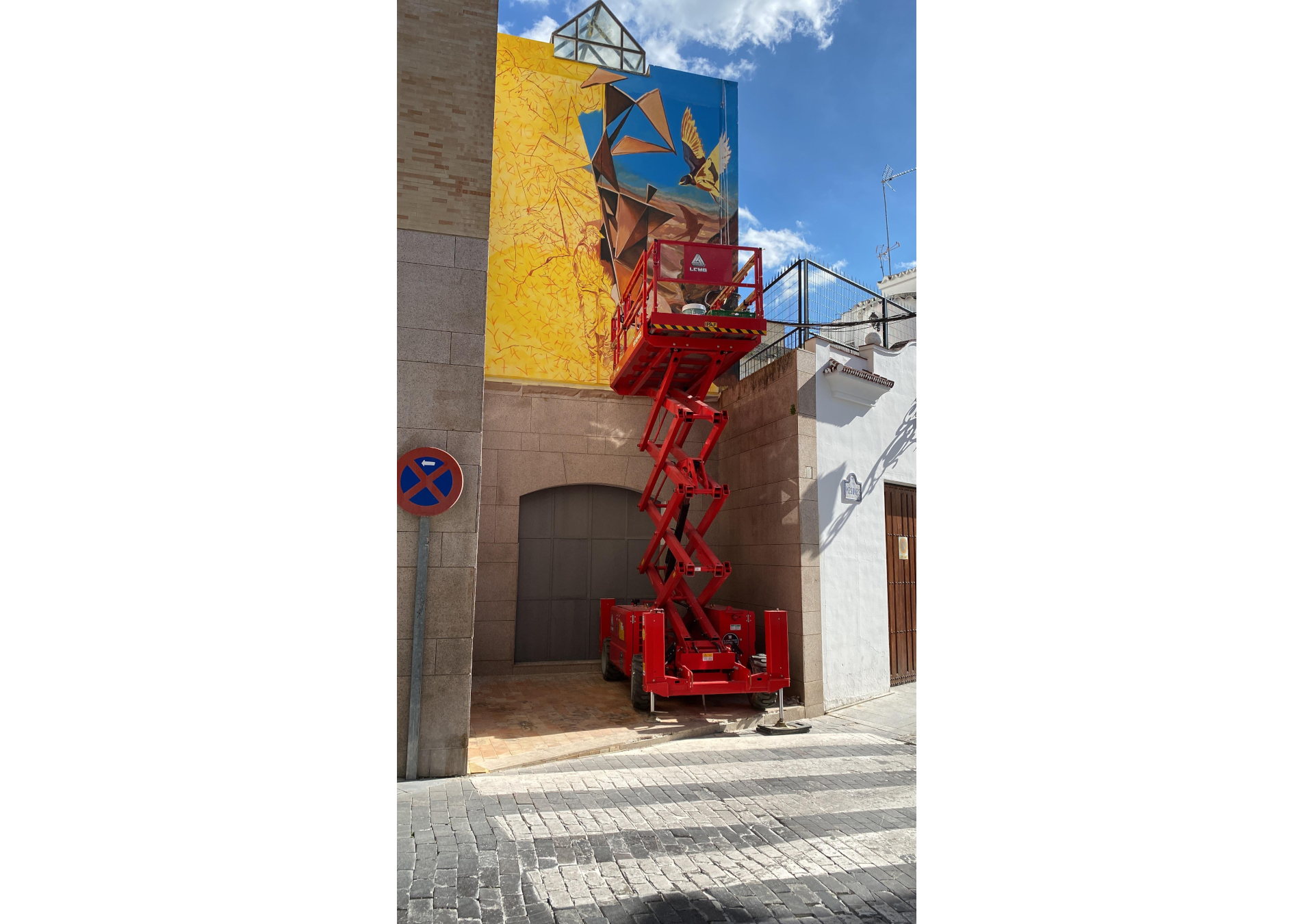 fresque murale réalisée en Espagne à Baena qui représente un personnage dans un paysage rocailleux surréaliste et entouré d'oiseaux.